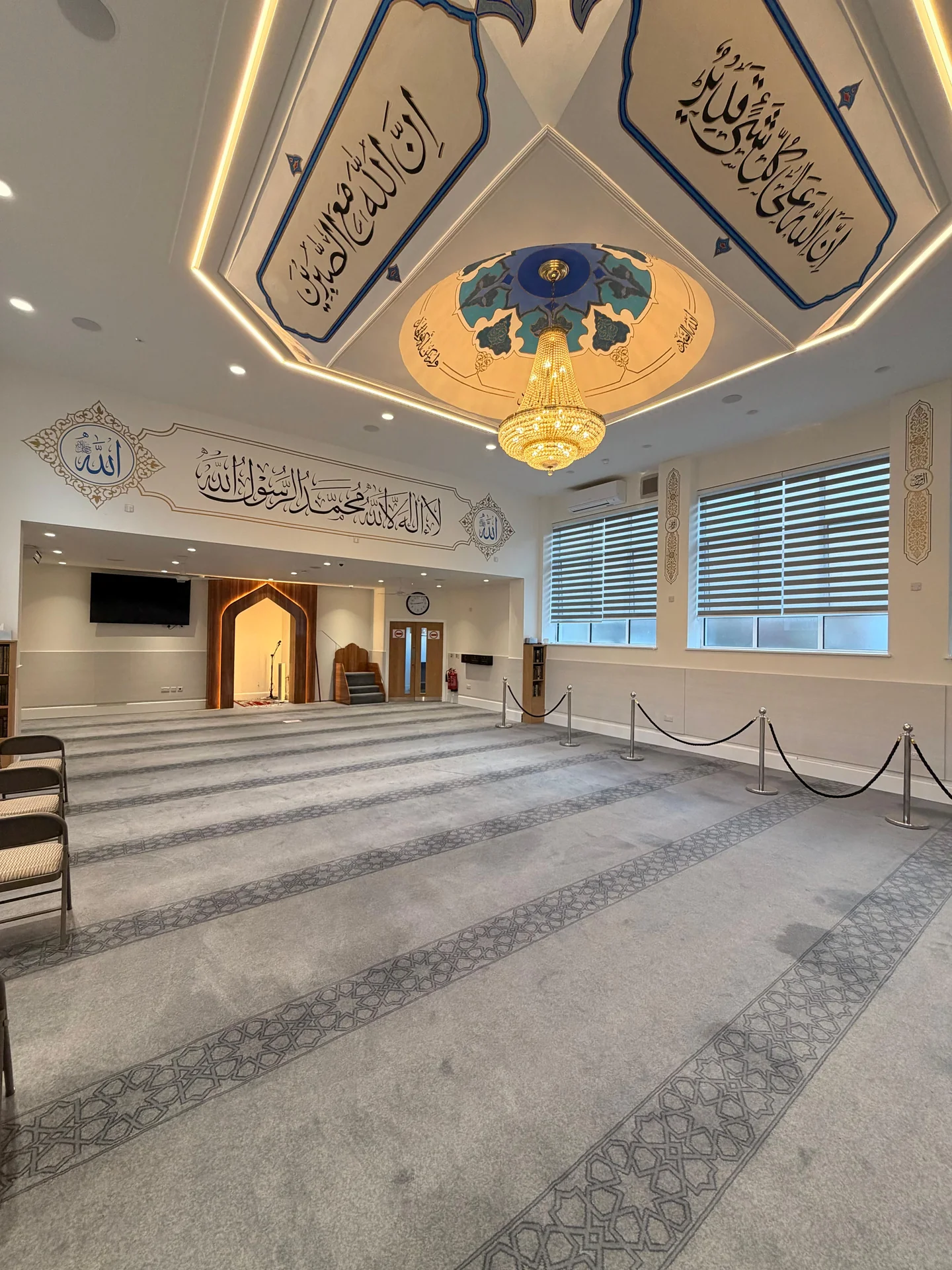Wide view of mosque calligraphy, decorated ceiling and prayer hall