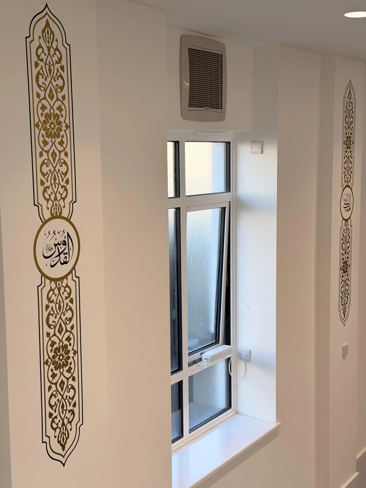 Ornamental gold calligraphy panels framing a mosque window