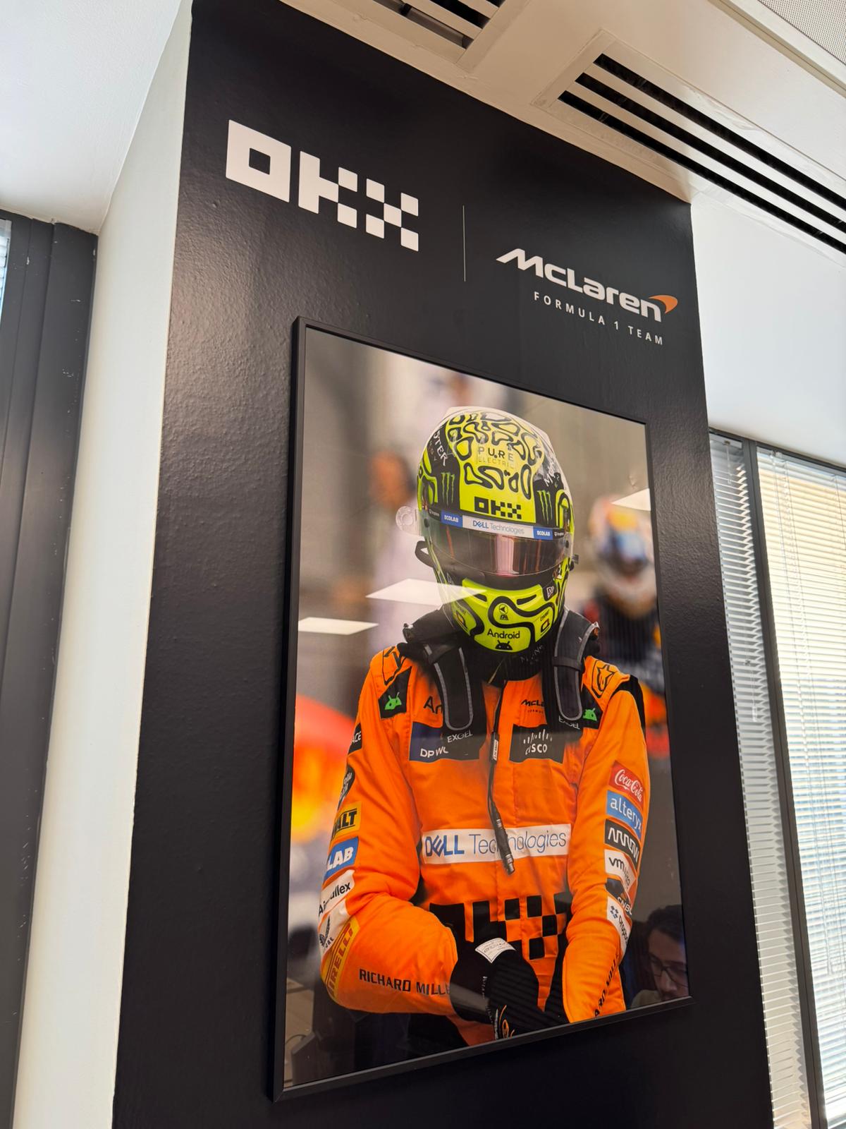 OKX and McLaren branded office wall with a driver portrait