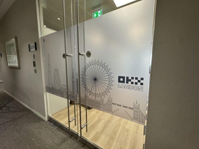 Frosted office glass with OKX and London skyline graphics
